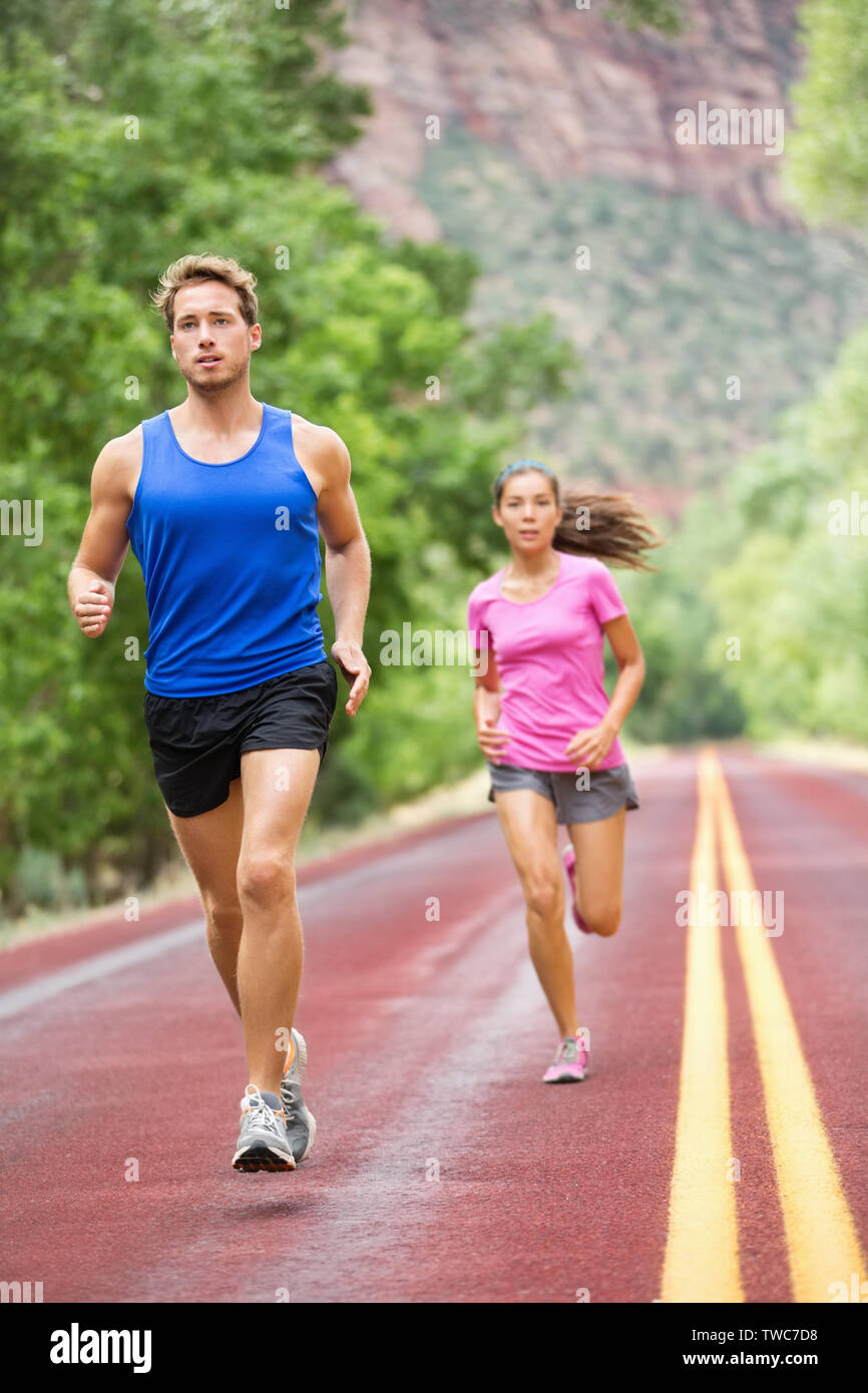 Ausführen von Menschen. Läufer Joggen im Sommer auf der Straße als Teil der gesunden, aktiven Lebensstil. Jogger Training für Marathon laufen. Passen männlichen und weiblichen Athleten in ihrem 20s. Asiatische Frau, kaukasische Mann. Stockfoto