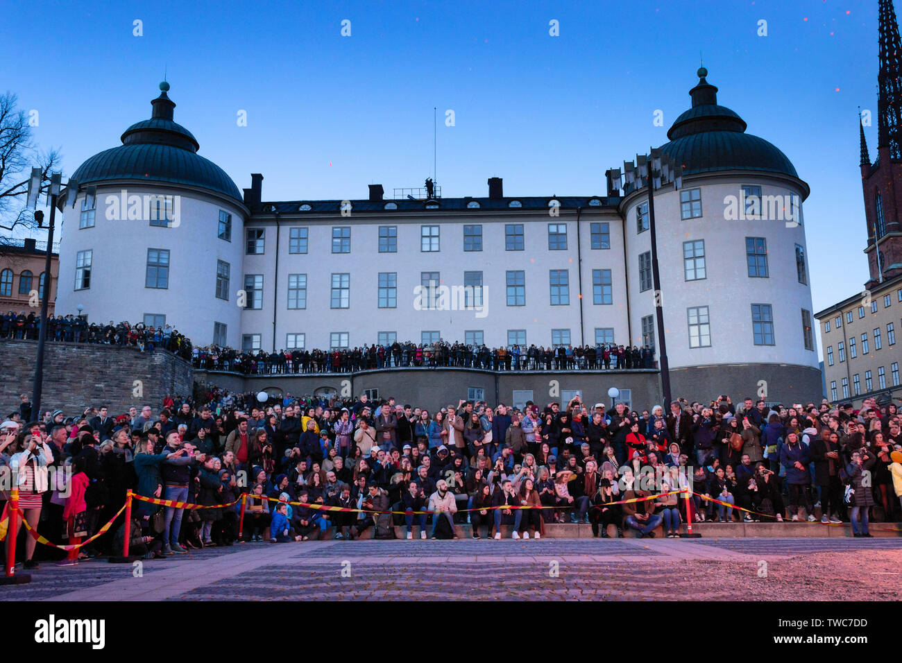 Touristen und lokale Menschenmassen vor dem Wrangel Palast, der vom brennenden Feuer angezündet wurde, der Feierlichkeiten zum Mayday Eve Valborg. Riddarholmen, Stockholm, SE Stockfoto