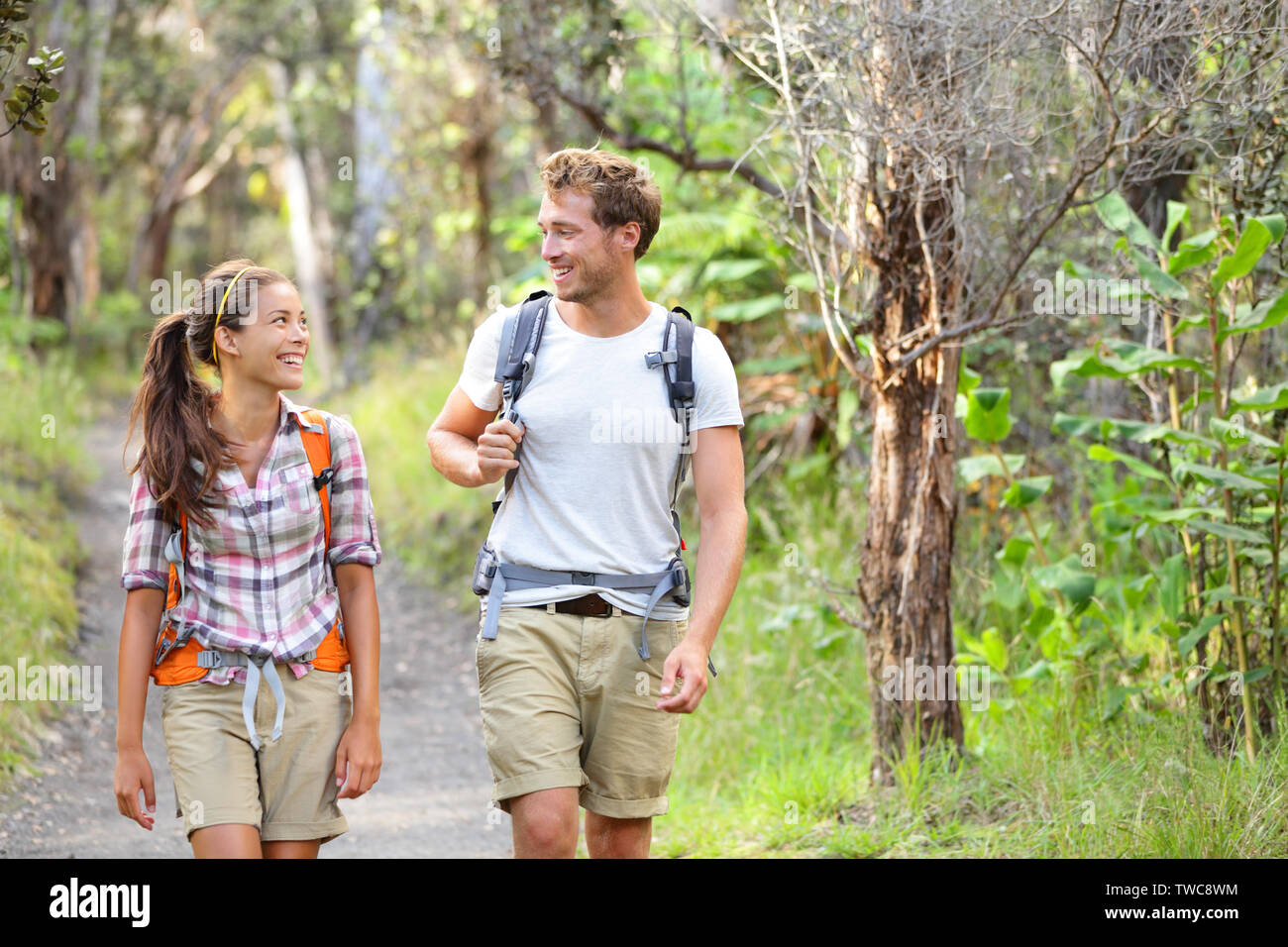 Wanderer Wandern Leute, die gerne im Wald. Wanderer paar Lachen und Lächeln. Interracial Paare, Kaukasier Mann und die asiatische Frau auf Big Island, Hawaii, USA. Stockfoto