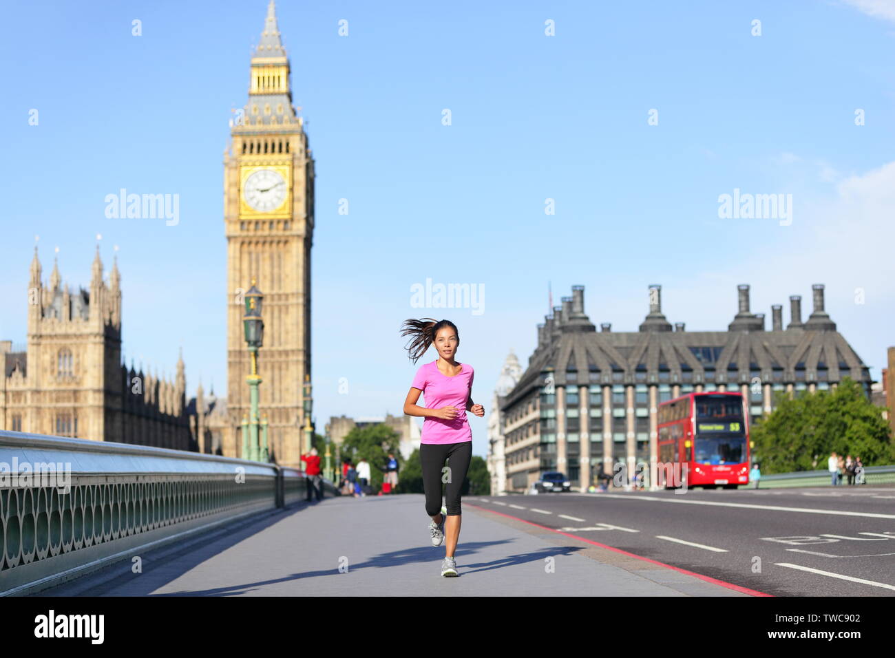London lifestyle Frau läuft in der Nähe von Big Ben. Läuferin joggen Training in der Stadt mit dem roten Doppeldeckerbus. Fitness Mädchen lächelte glücklich auf die Westminster Bridge, London, England, Vereinigtes Königreich. Stockfoto