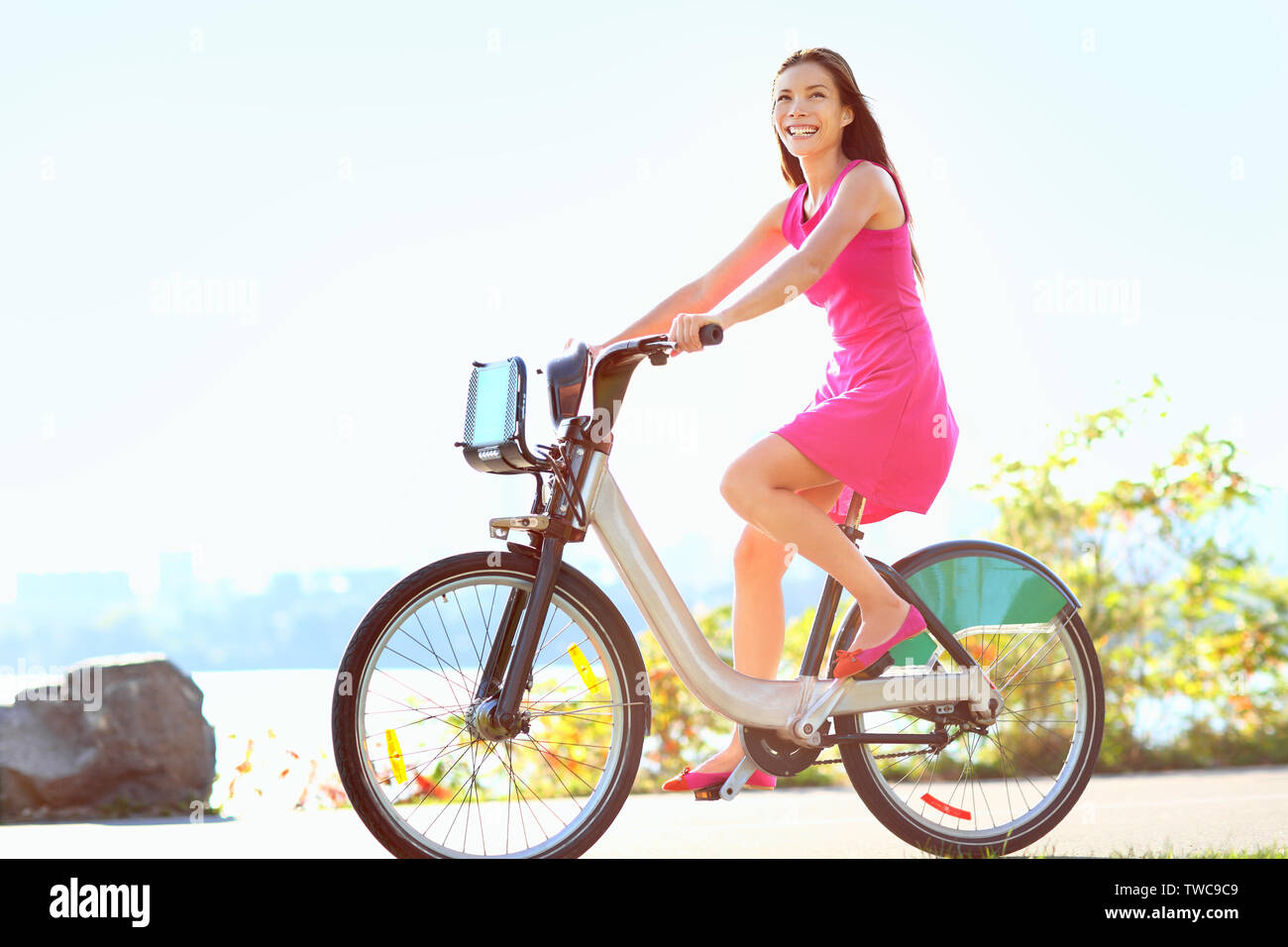 Mädchen Fahrrad fahren in der Stadt auf dem Fahrrad. Glückliche Frau auf Fahrrad Radfahren im Freien im Sommer ein Lächeln der Freude bei Aktivitäten im Freien. Gemischten rennen Kaukasischen asiatische Frau Modell. Stockfoto