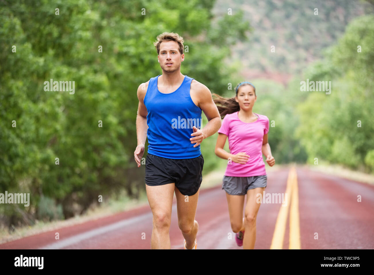 Fitness Laufen junge Paar training Marathon konzentrierte sich auf Road Trail im Sommer Natur konzentriert. Sportlich gesund gemischten Rasse Frau und stattlichen kaukasischen Mann joggen außerhalb. Sportliche Menschen in 20 s Stockfoto