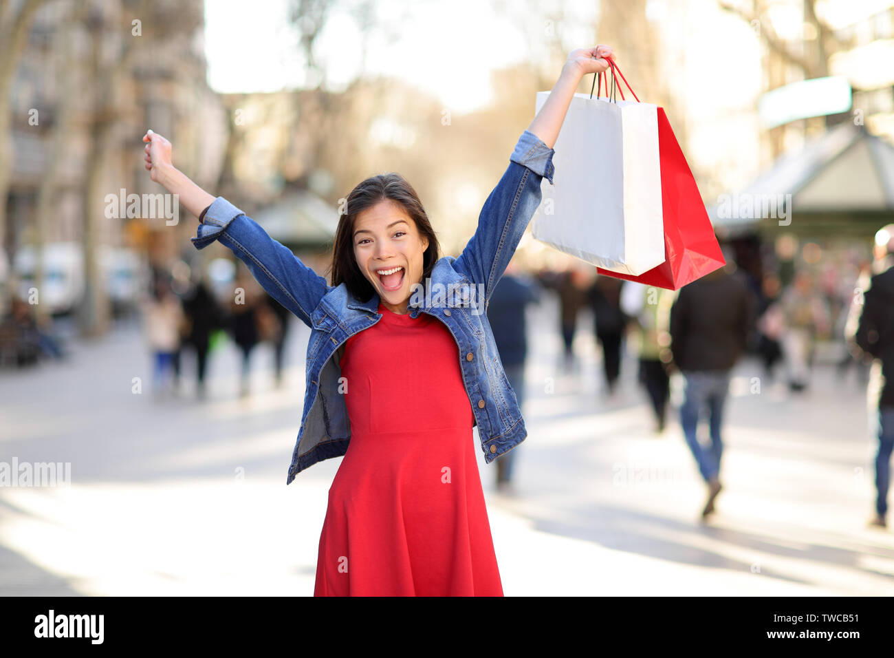 Shopping Frau auf La Rambla Straße in Barcelona zufrieden. Shopper girl Holding Einkaufstaschen bis aufgeregt im Freien auf Walking Street. Gemischte Rasse asiatischen Kaukasischen weibliche Modell fröhlich in Spanien. Stockfoto