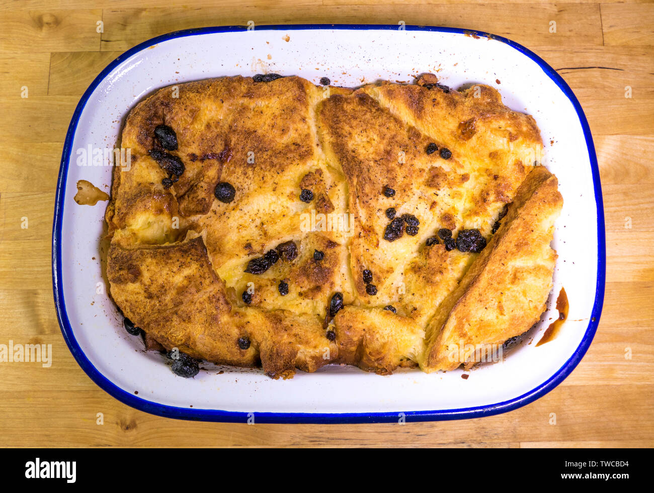 Nahaufnahme von oben auf ein ganzes Brot und Butter Pudding Dessert in einem emamel Auflaufform, heiß aus dem Ofen. Stockfoto