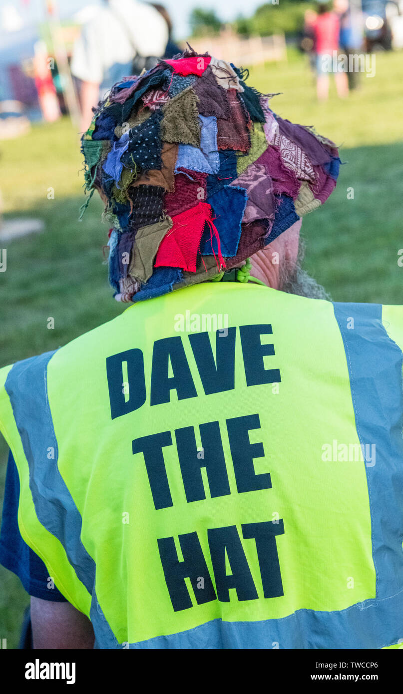 Mann mit einem Patchwork Hut und ein Hi-vis Jacke mit 'Dave der Hut" auf der Rückseite gedruckt. Stockfoto