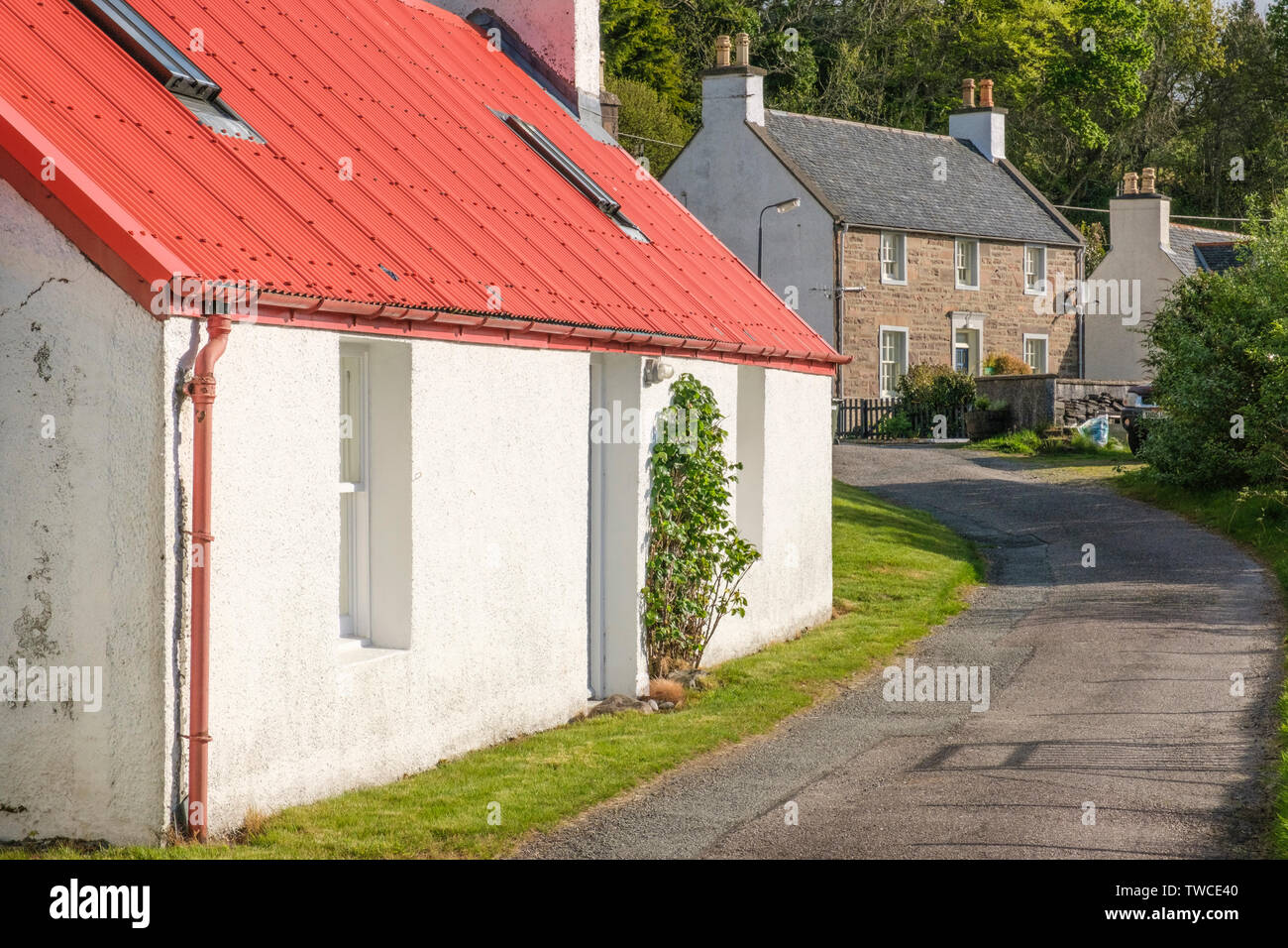Ehemaliges Armenhaus im Vordergrund mit ehemaligen Polizeistation in Lochcarron Dorf, Wester Ross, Highlands von Schottland Stockfoto