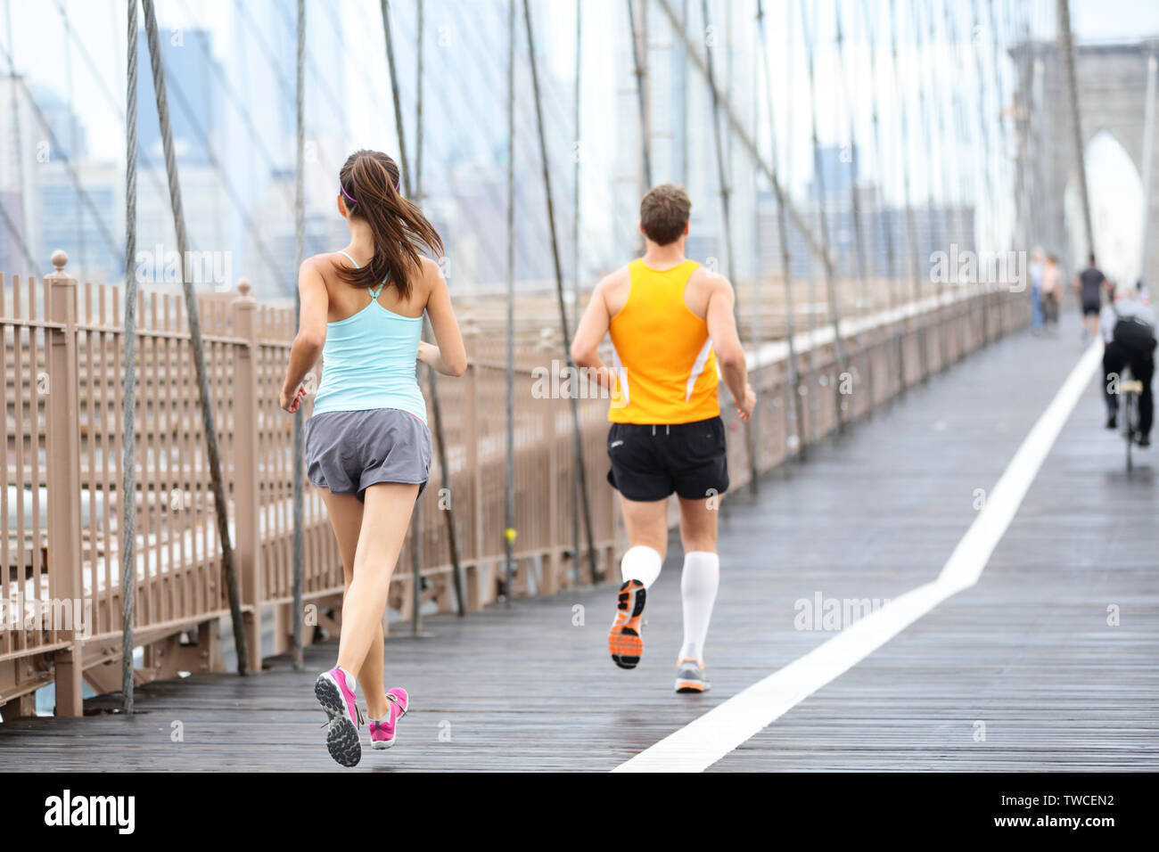 Die Menschen laufen joggen Training für den New York Marathon. Läufer auf Ausführen. Mann und Frau fitness Sport Modell Joggen auf der Brooklyn Bridge, New York City, USA. Stockfoto