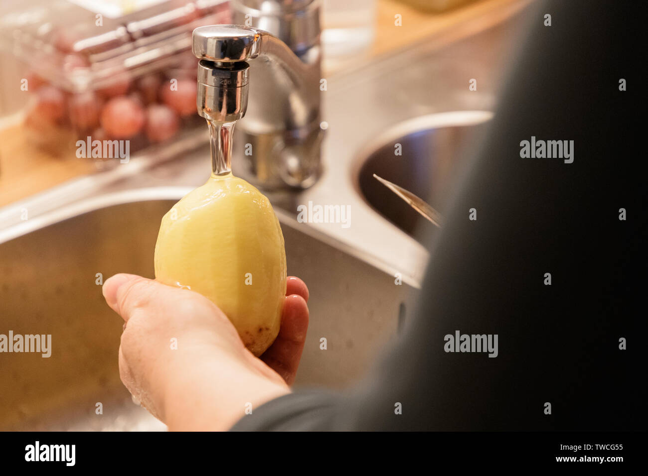 Frau Schälen von Kartoffeln über ein Spülbecken closeup Stockfoto