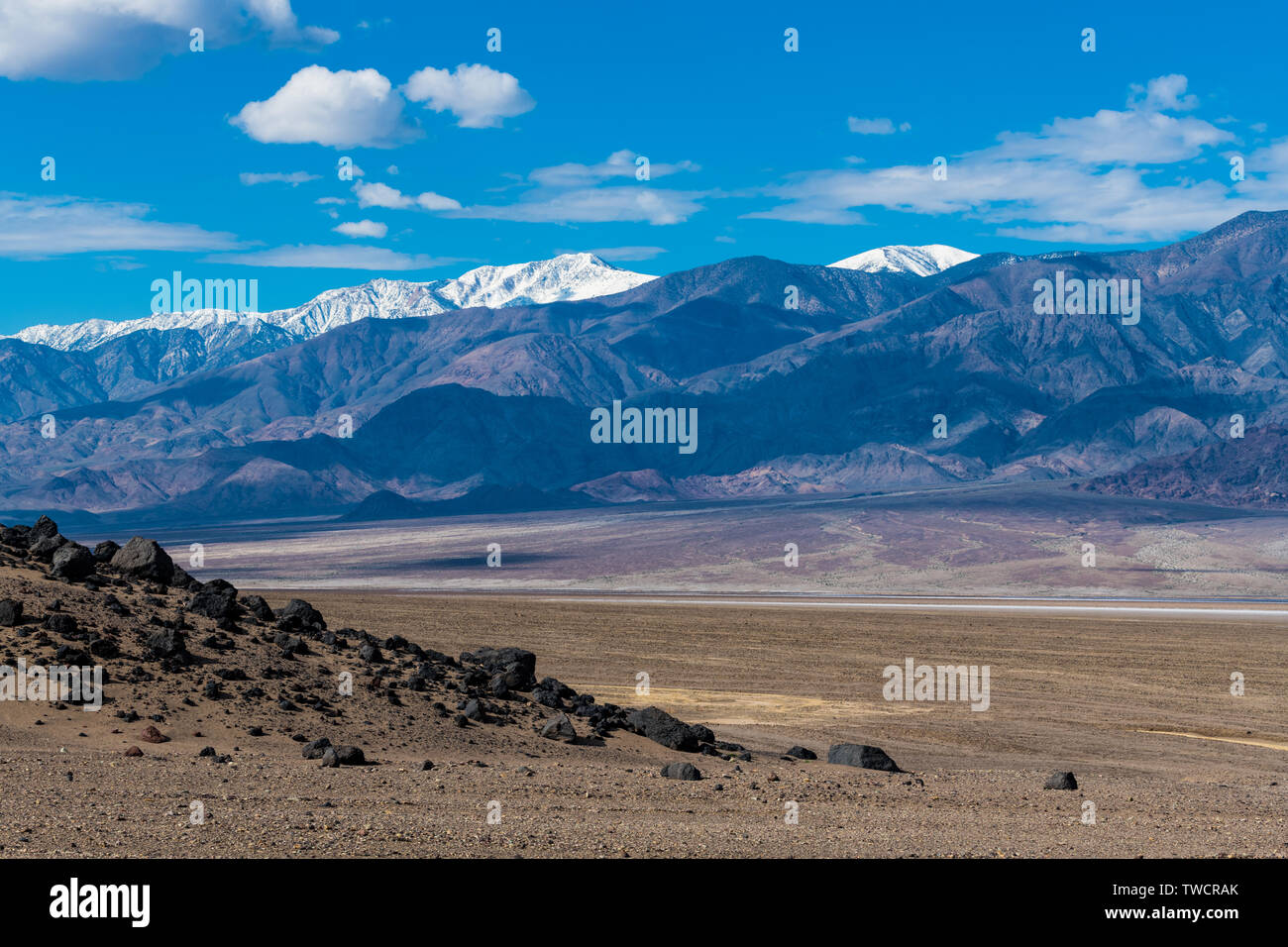 Die unfruchtbare Erde und Felsen von einer trockenen Wüste Landschaft mit hohen schneebedeckten Gipfeln - Panamint Range im Death Valley National Park gegenüber Stockfoto