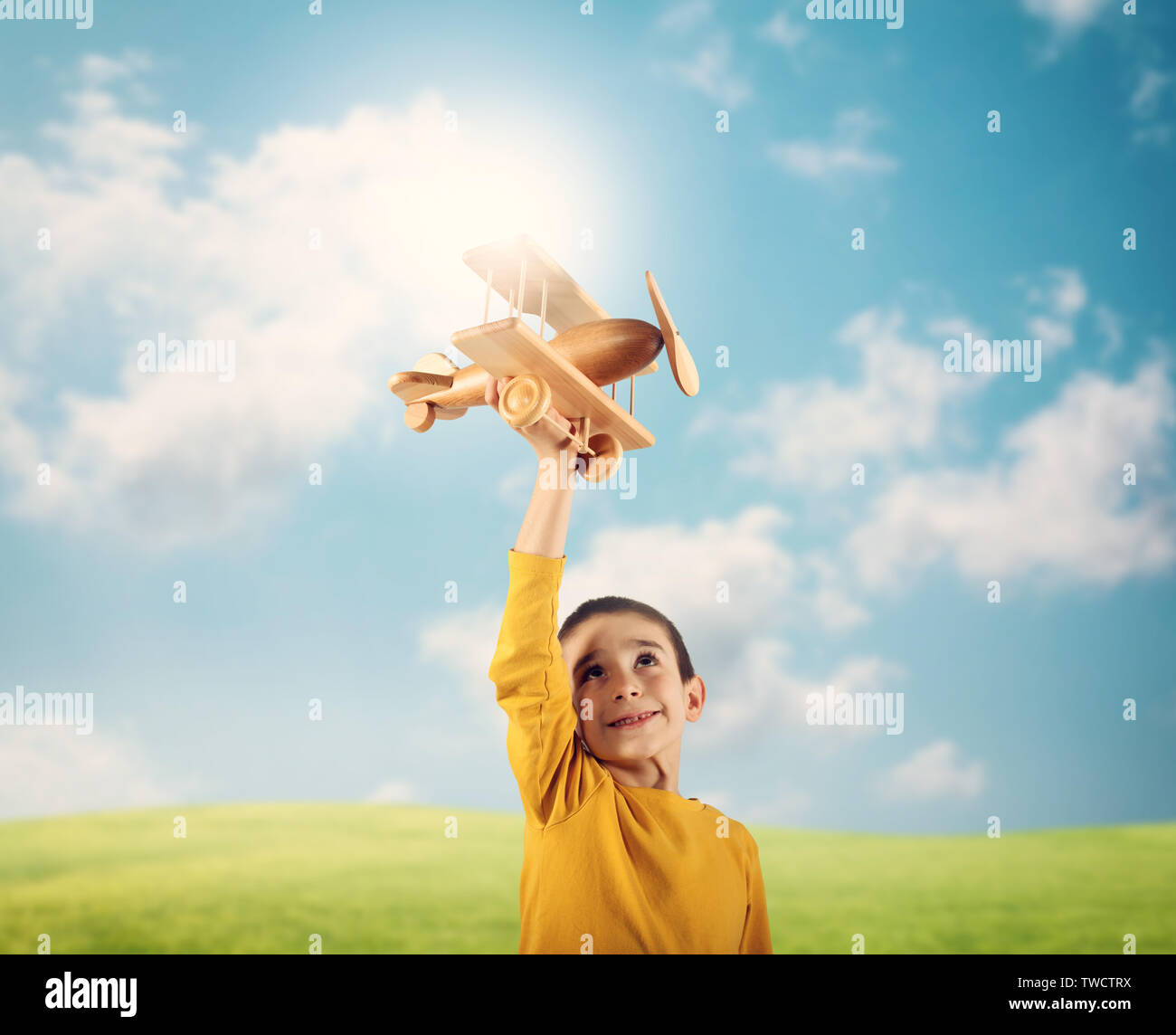 Kind spielt mit einem hölzernen Spielzeug Flugzeug Stockfoto