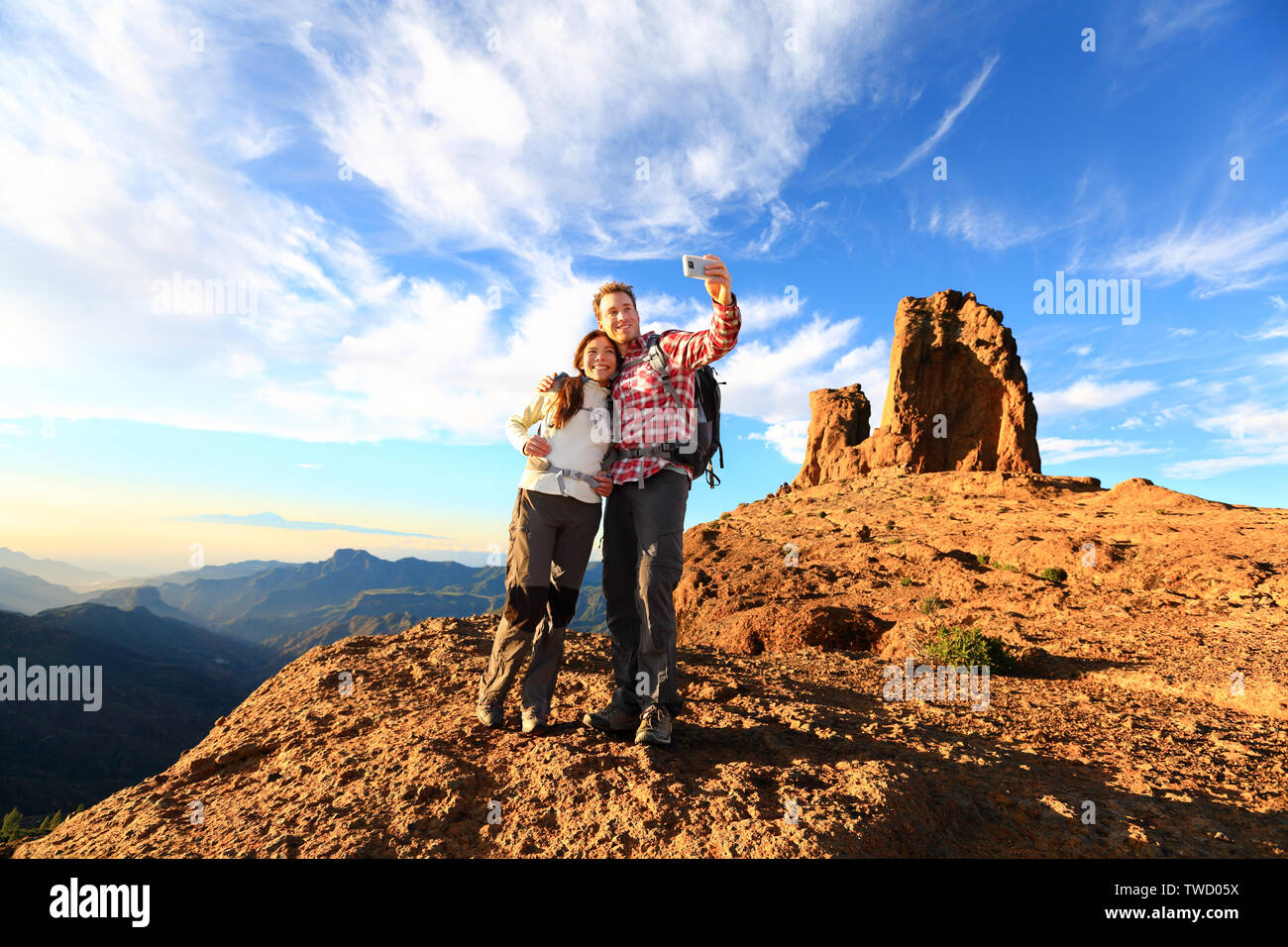 Paar unter selfie Wandern in schöner Natur mit Smart Phone. Glückliches Paar zu Fuß genießen Ansehen und Aufnehmen von Bildern mit Smartphone. Mann und Frau von Roque Nublo, Gran Canaria, Kanarische Inseln. Stockfoto