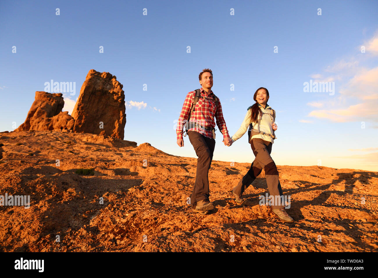 Wanderer Wandern in einer wunderschönen Landschaft. Wandern Paar Mann und Frau trekking Wandern mit Rucksäcken in Trail bei Sonnenuntergang in den Bergen von Roque Nublo, Gran Canaria, Kanarische Inseln, Spanien. Stockfoto
