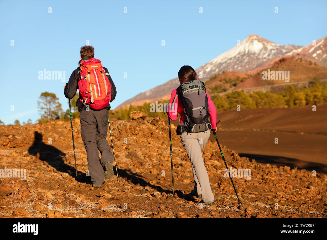 Wandern Menschen - gesunden, aktiven Lebensstil Paar. Wanderer zu Fuß in die hintere Ansicht von hinten in der herrlichen Bergwelt. Frau und Mann zu Fuß auf Wanderung auf den Vulkan Teide, Teneriffa, Kanarische Inseln, Spanien. Stockfoto