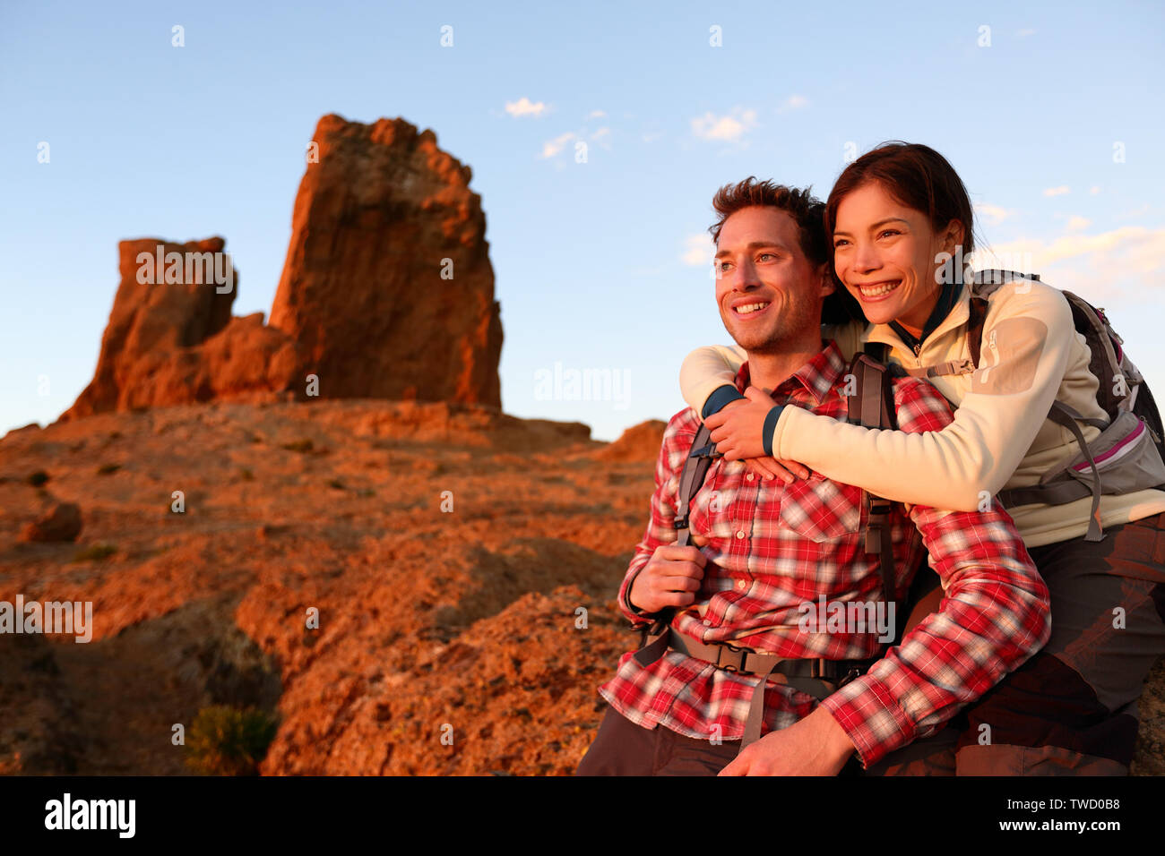 Glückliches Paar aktiven Lifestyle wandern aktiv im Freien genießen. Lächelnd lachend jungen Liebhaber bei Sonnenuntergang während der Wanderung in den Bergen von Roque Nublo, Gran Canaria, Kanarische Inseln, Spanien. Stockfoto