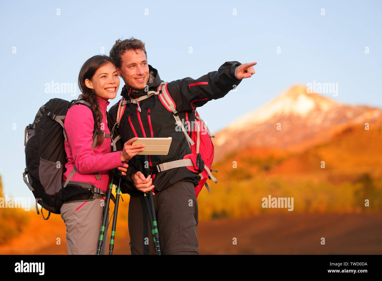 Tablet PC - Wandern Paar mit Travel App oder Karte auf Wanderung. Mann und Frau Wanderer auf Ansicht zeigen und zeigen während der Wanderung auf den Vulkan Teide, Teneriffa, Kanarische Inseln, Spanien. Stockfoto