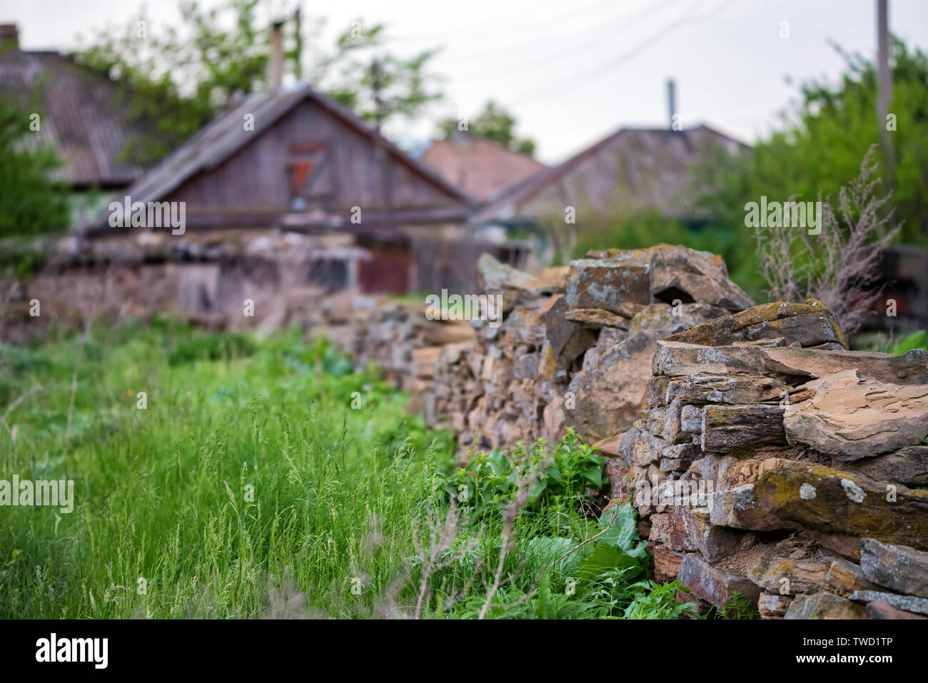 Angesichts der niedrigen Stein Zaun um den Garten und die ländliche Haus im Hintergrund Stockfoto