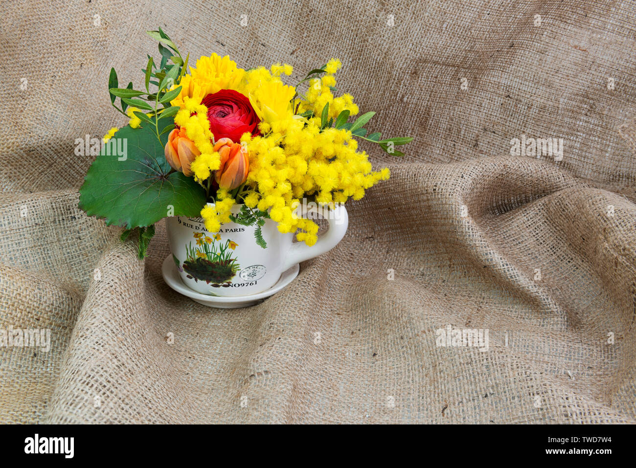 Frühling Blumen Zusammensetzung auf einem Sack Hintergrund mit Platz für Text Stockfoto