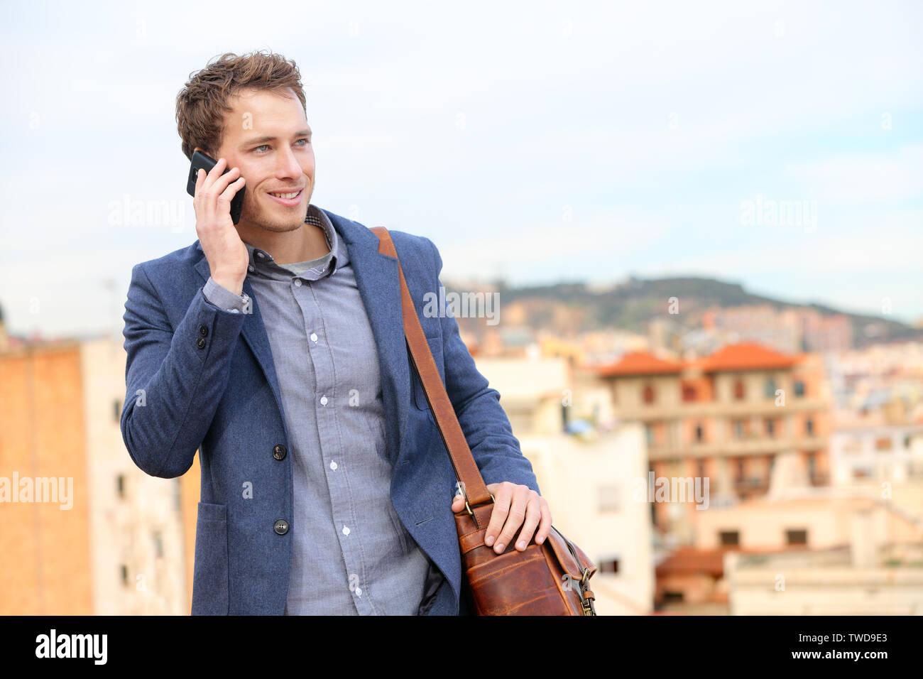 Mann auf dem Smartphone - Young Business Mann auf Smart Phone. Casual urban professional Geschäftsmann mit Mobiltelefon lächelt glücklich Wandern. Stattlicher Mann mit Anzug Jacke in Barcelona, Spanien Stockfoto