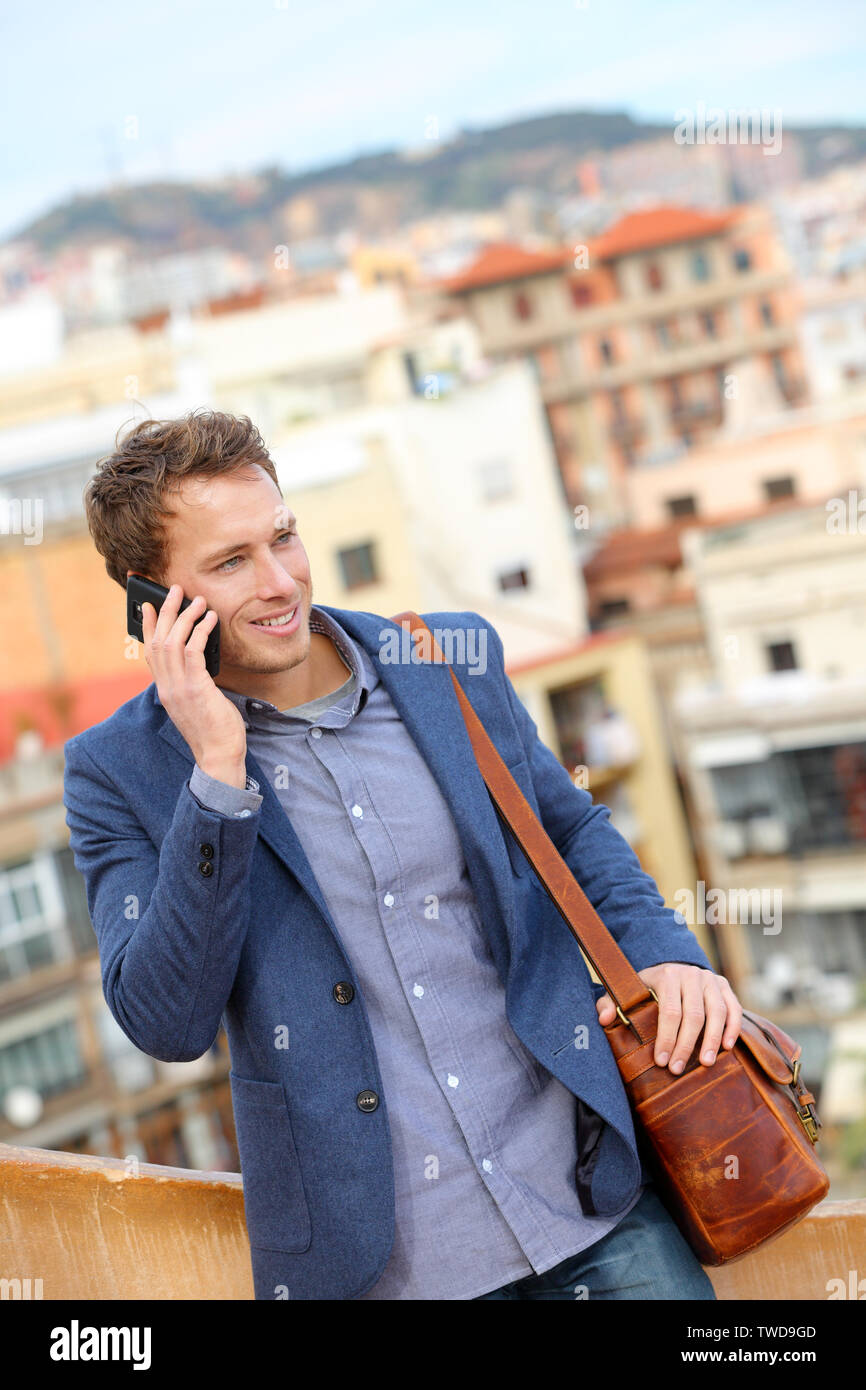 Mann auf smart phone - Young Business Mann auf dem Smartphone. Casual urban professional Geschäftsmann mit Mobiltelefon lächelt glücklich Wandern. Stattlicher Mann mit Anzug Jacke in Barcelona, Spanien Stockfoto