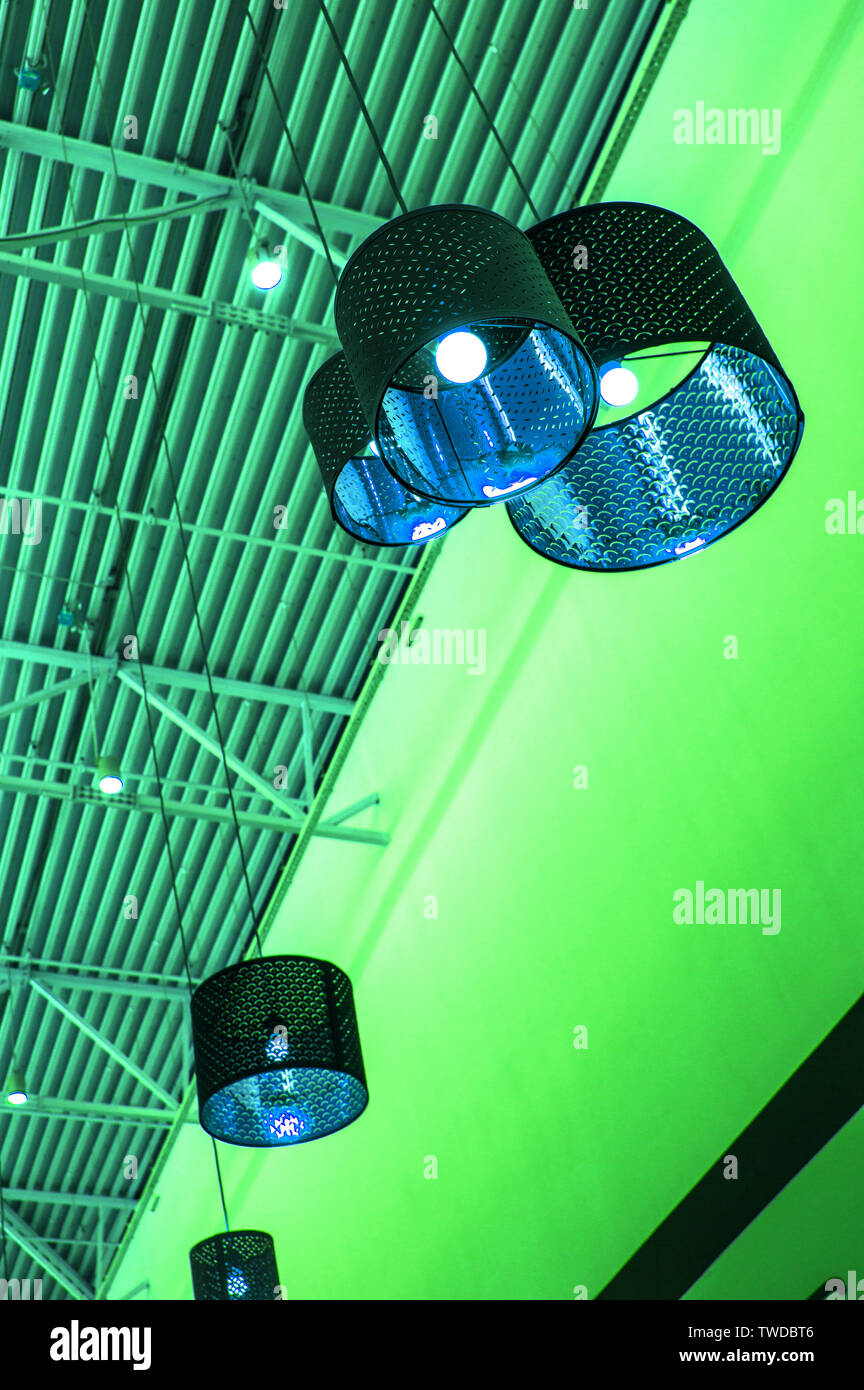 Ultra-modernen Stil in grün getönten Farben dekorative Lampen und Lampenschirme hängen an langen Seil, industriellen Decken, Innenausbau vertikale erschossen. Stockfoto