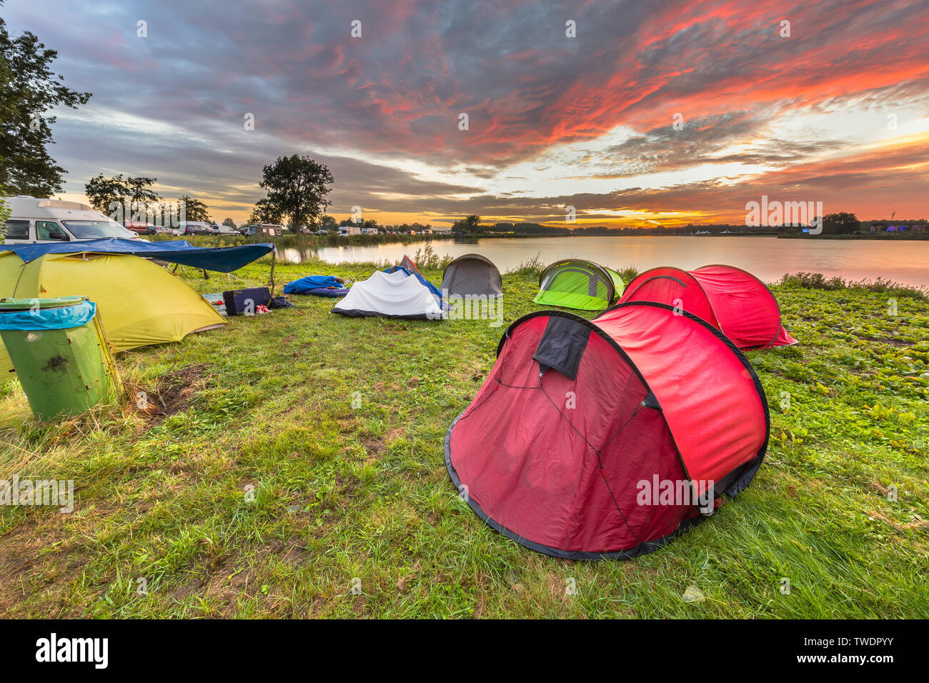 Campingplatz mit Dome Zelte in der Nähe von See auf ein Musik Festival camp site unter schönen Sonnenaufgang Stockfoto