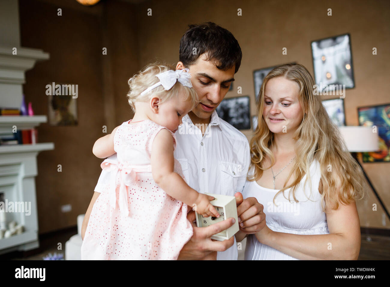 Zärtliche Umarmungen der Familie. Glücklich schwangere Mutter, Vater, Tochter genießen einander zu Hause Stockfoto