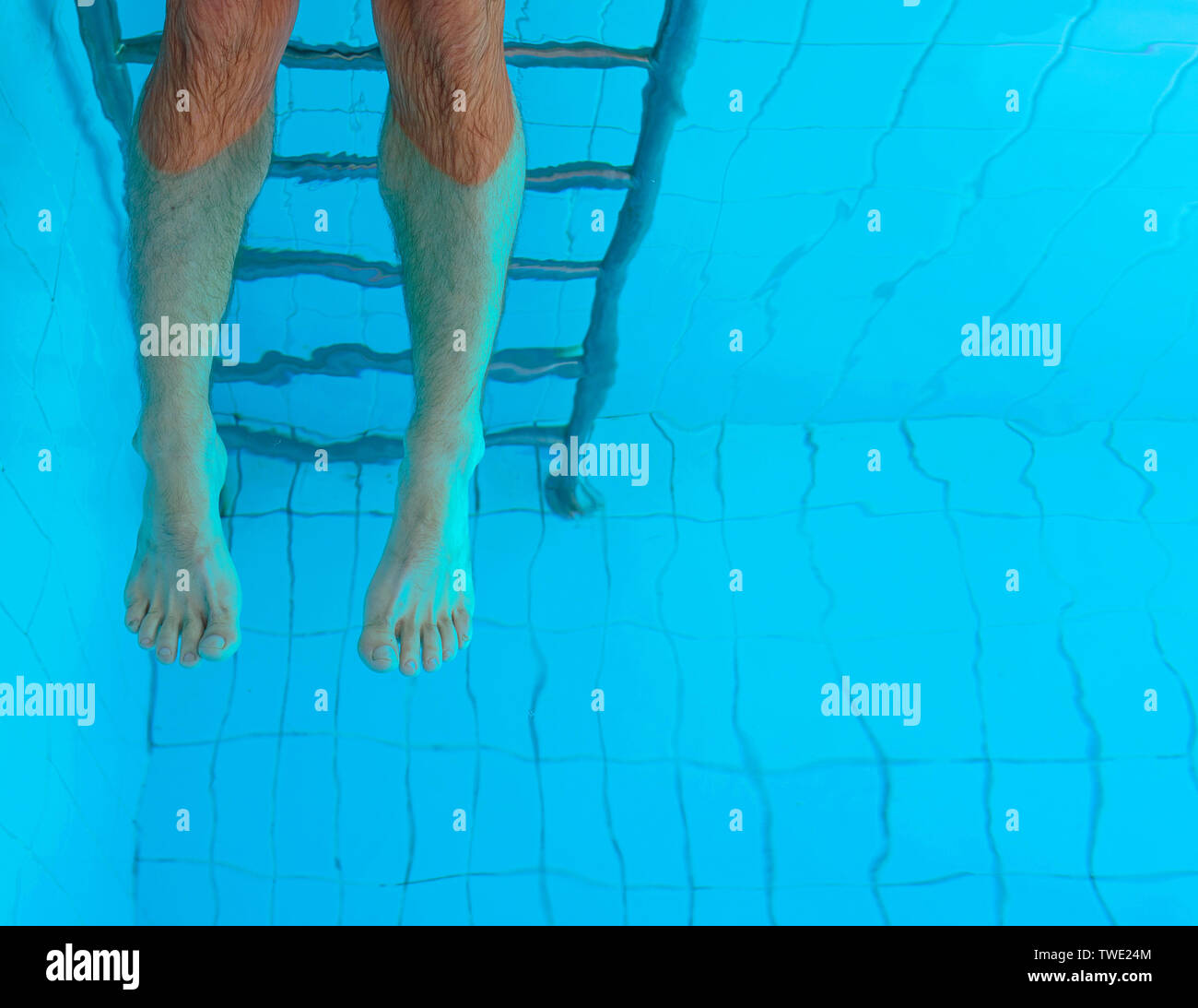 Die Beine unter Wasser in den Pool nach cuacasian Mann. Sommer. Urlaub und Sport Konzept. Stockfoto