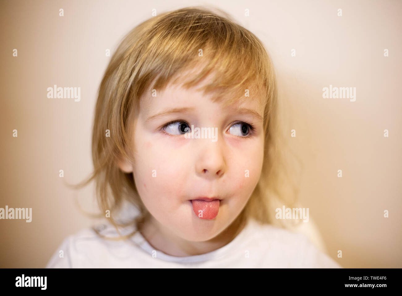 Süß lächelnd kleine Blonde kaukasier kind Mädchen Gesicht Nahaufnahme portrait Mit herausgestreckter Zunge Stockfoto