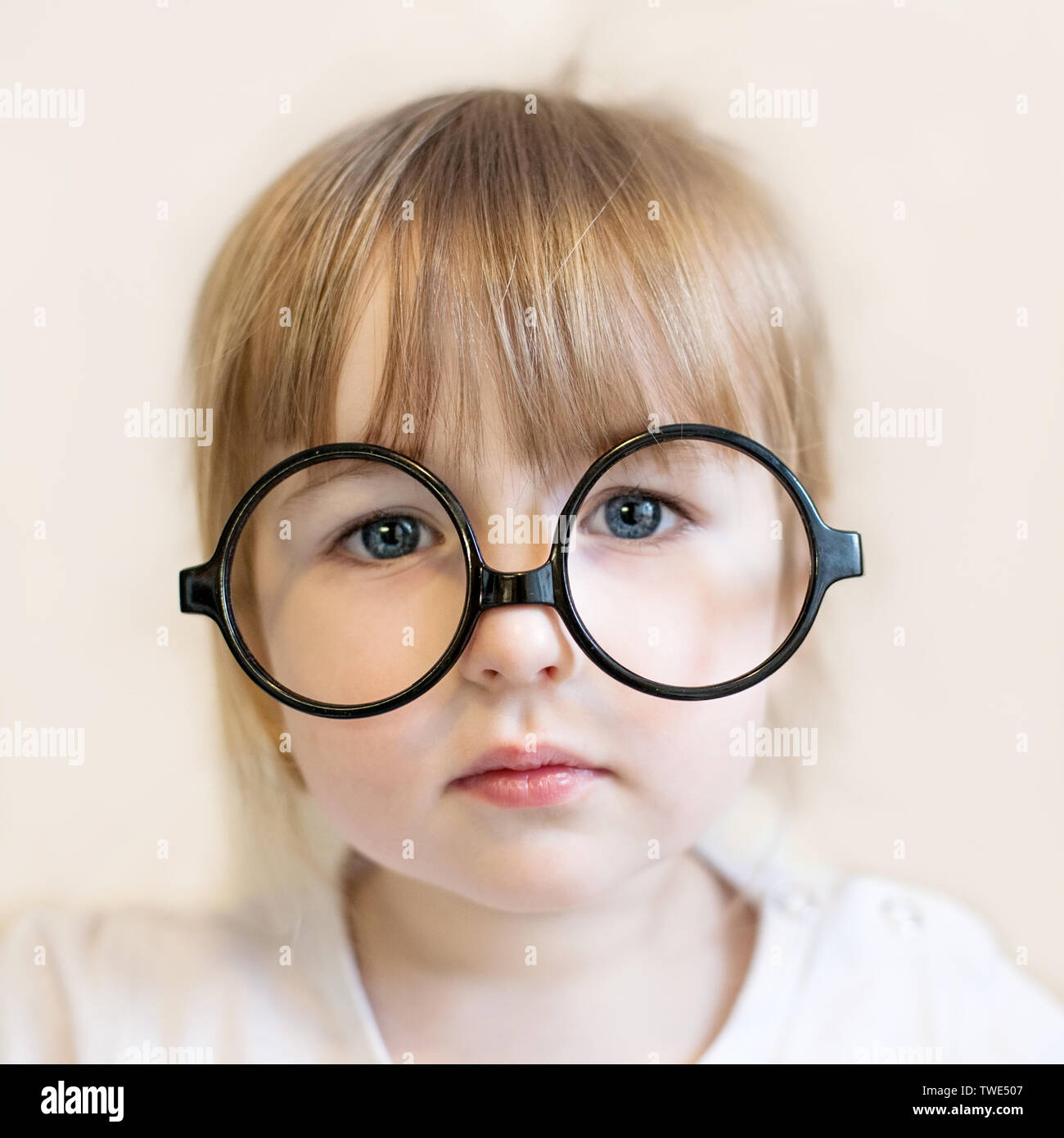 Niedliche kind Mädchen mit grossen runden schwarzen Lehrer Brille auf der Nase Stockfoto
