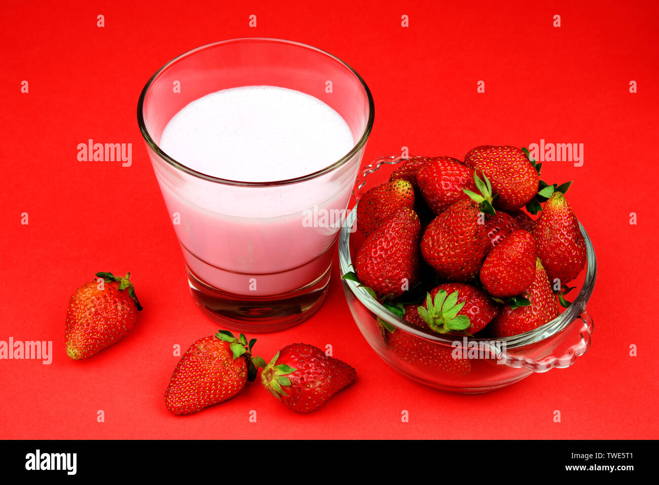 Frische, Reife und saftige Erdbeere Obst in einer Schüssel mit einem Glas Erdbeer shake oder smoothy Stockfoto