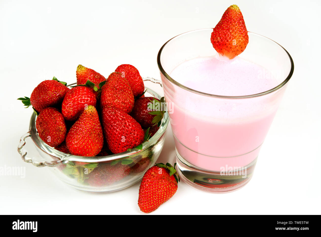 Frische, Reife und saftige Erdbeere Obst in einer Schüssel mit einem Glas Erdbeer shake oder smoothy Stockfoto