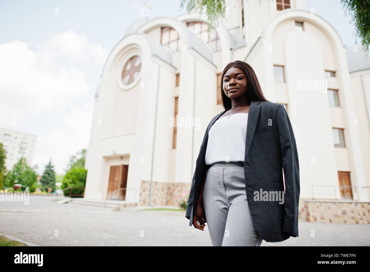 Afrikanische amerikanische Frau im Freien gegen Kirche und betet zu Gott. Konzept für den Glauben, Spiritualität und Religion. Stockfoto