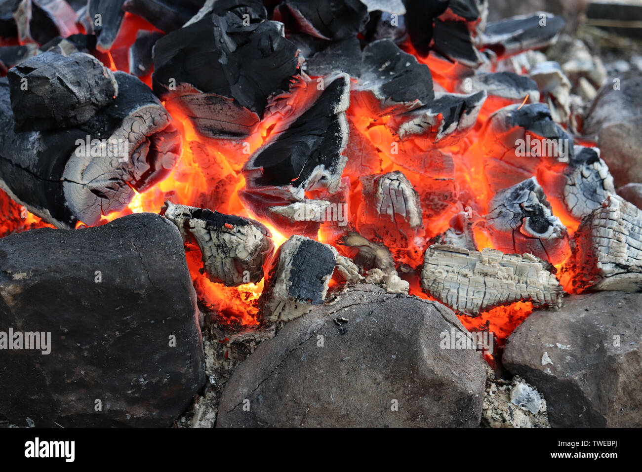 Schwelende Glut in einem Feuer, das Verbrennen von Holz, Lagerfeuer für Hintergrund Stockfoto