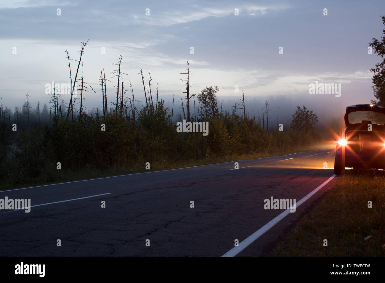 Auto mit Scheinwerfern auf der Seite der Straße Stockfoto