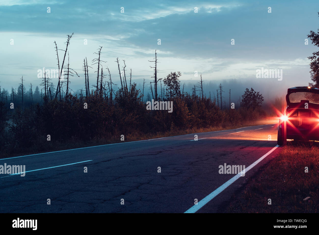 Auto mit Scheinwerfern auf der Seite der Straße Stockfoto