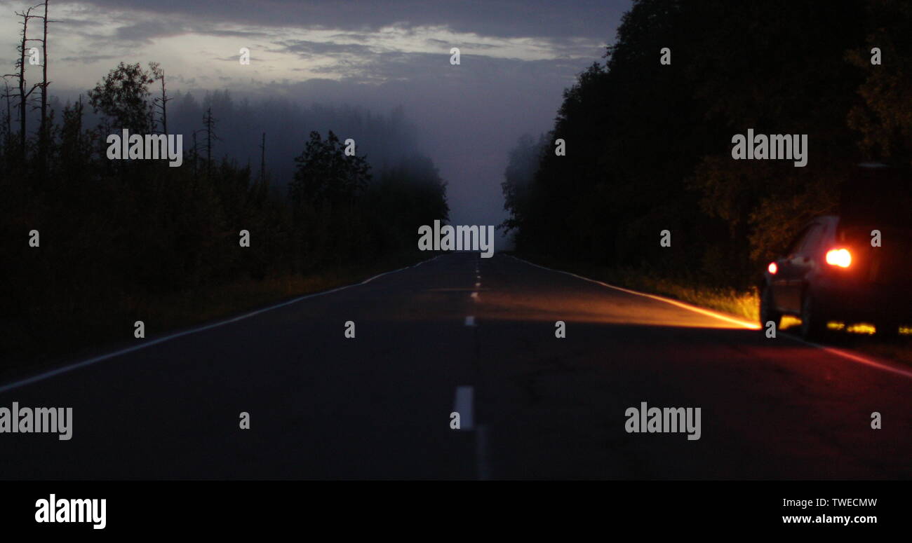 Auto mit Scheinwerfern auf der Seite der Straße Stockfoto