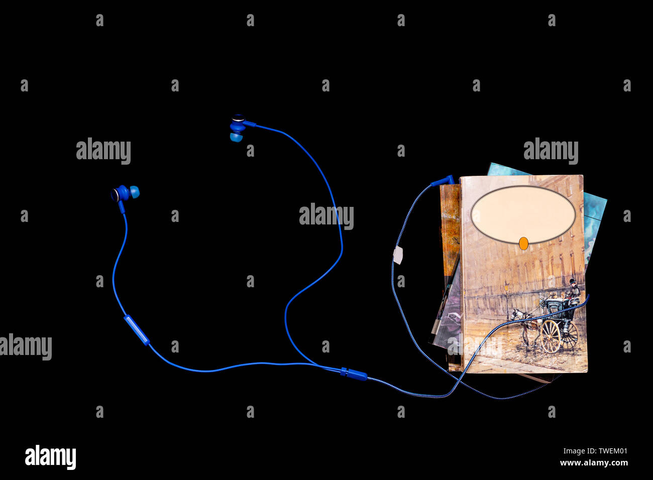 Audio Bücher und moderner Technologie Konzept - Stack der Kunst Bücher mit blauen Kopfhörer entwined, Isolation auf schwarzem Hintergrund, flatlay Stockfoto