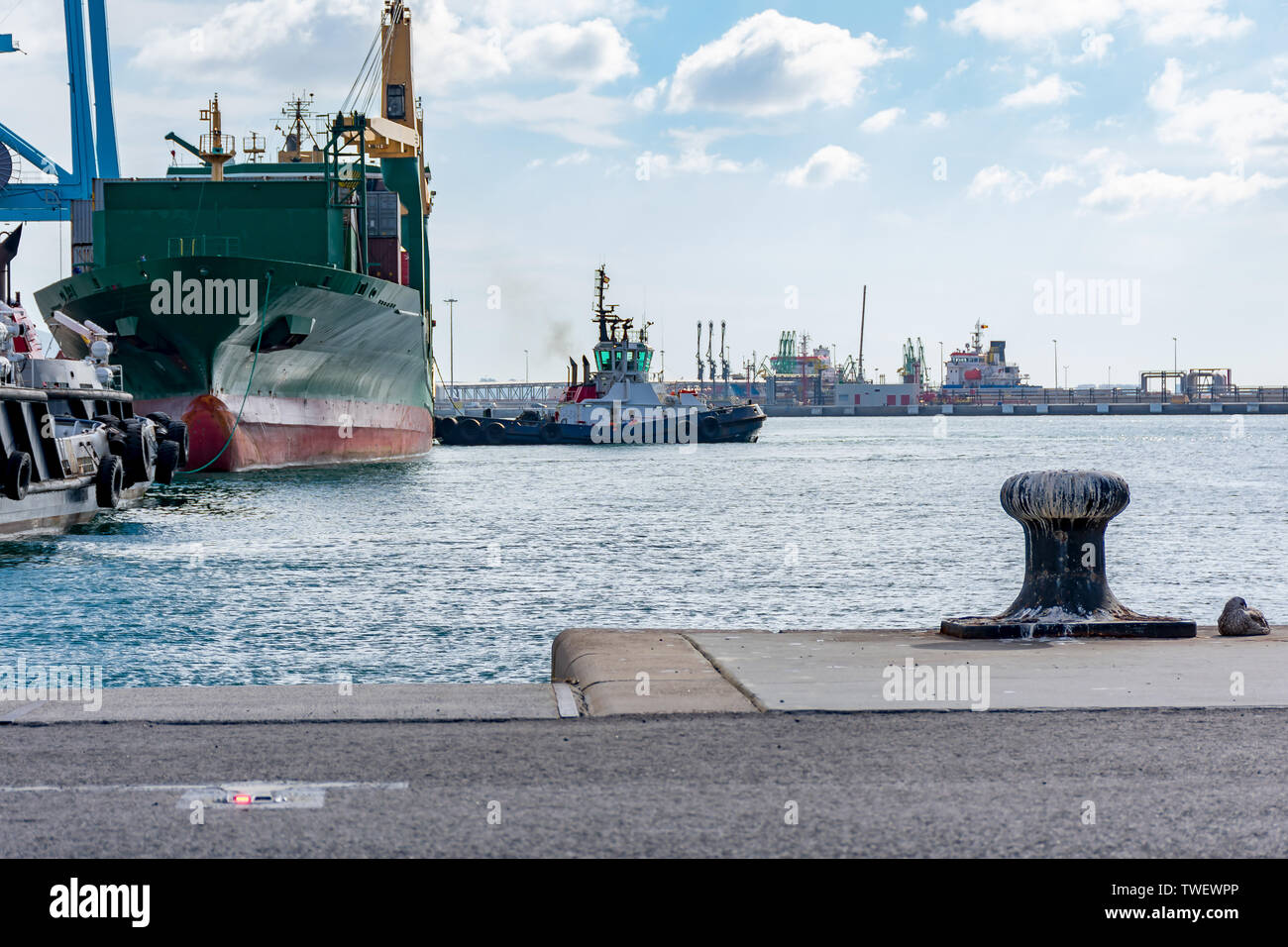 Tugboat Docking ein Containerschiff in den Hafen von Algeciras Stockfoto