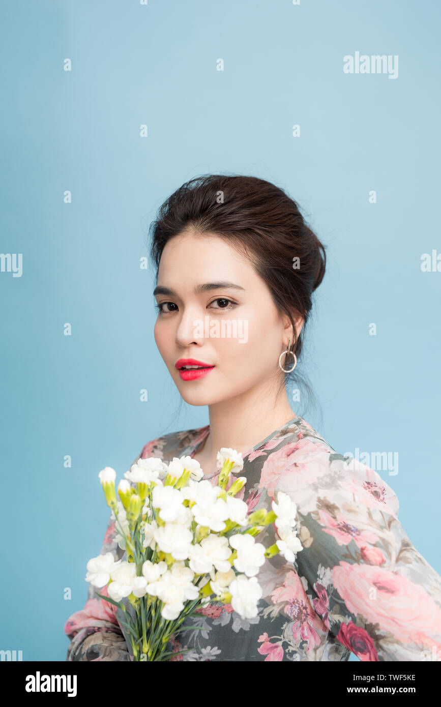 Portrait von Ausschreibung Asien Frau mit Blumenstrauß auf blauem Hintergrund Stockfoto