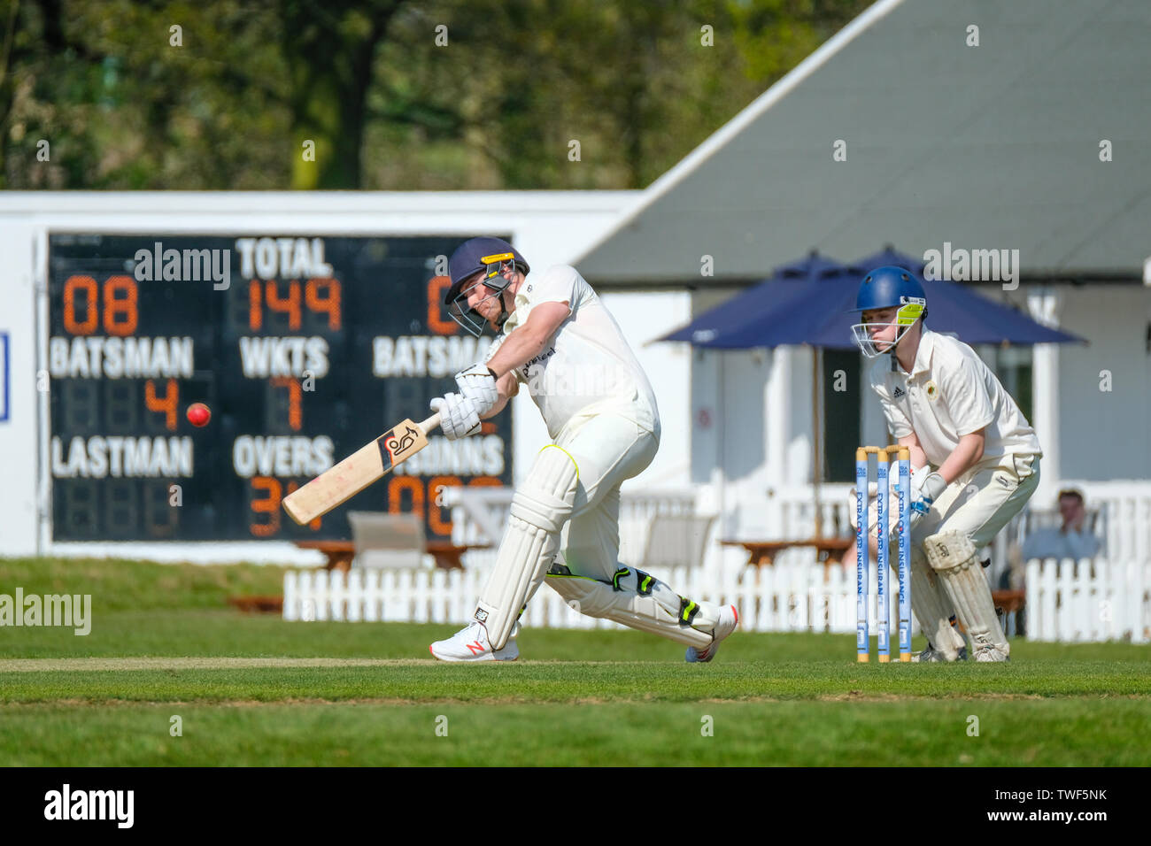 Batsman spielt einen Schuß in Richtung Mitte an einem Kricketspiel zu Rothley in Leicestershire. Stockfoto