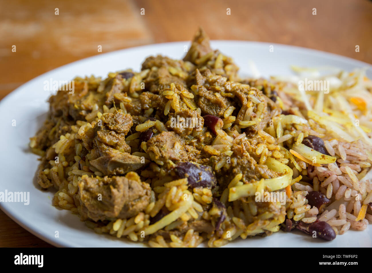 Die jamaikanische Essen. Jamaican Curry Goat serviert mit Reis und Erbsen Stockfoto