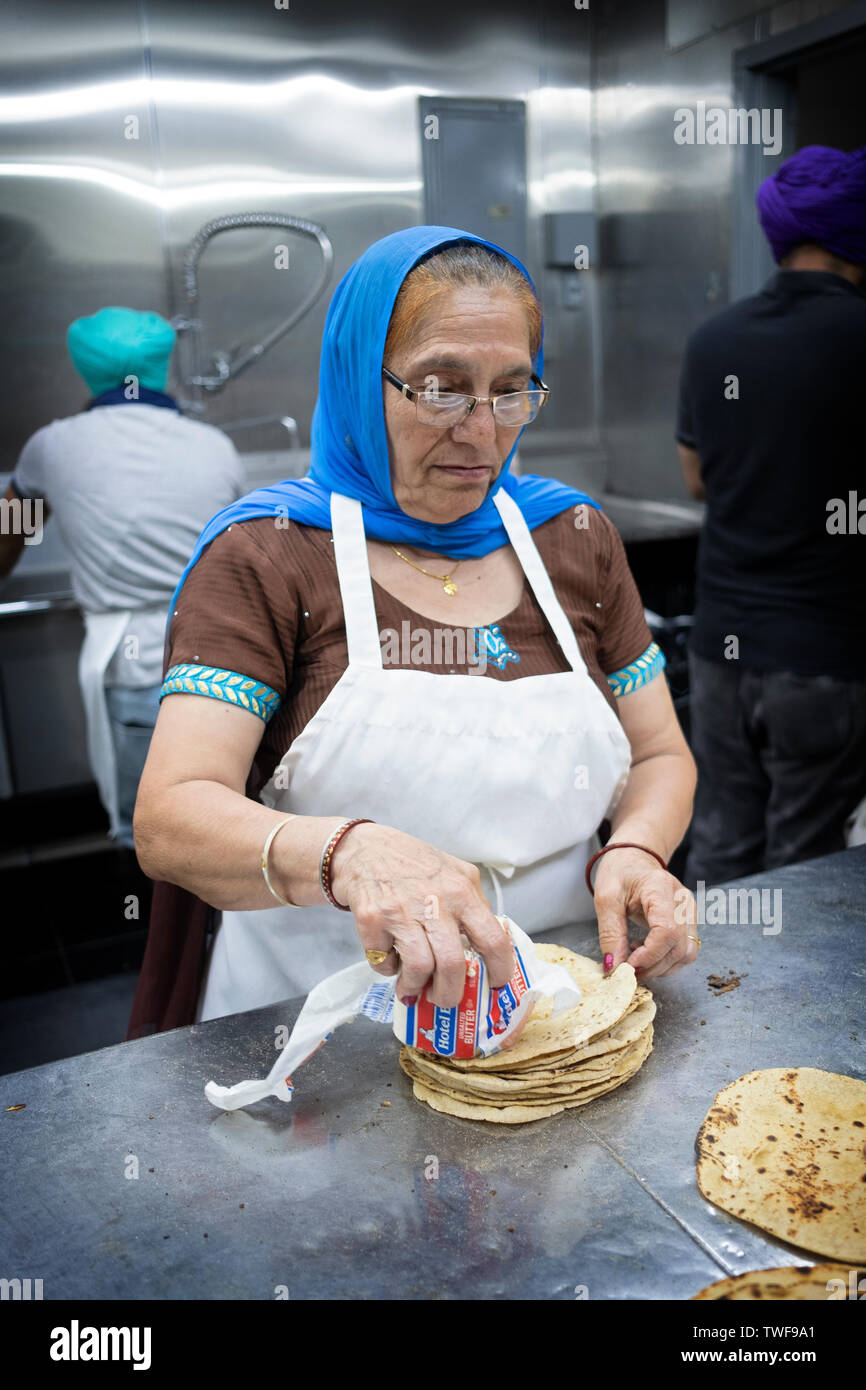 Eine ältere Sikh Frau freiwillig macht roti Brot in der langar die Sikh Center in New York in Flushing, Queens. Stockfoto