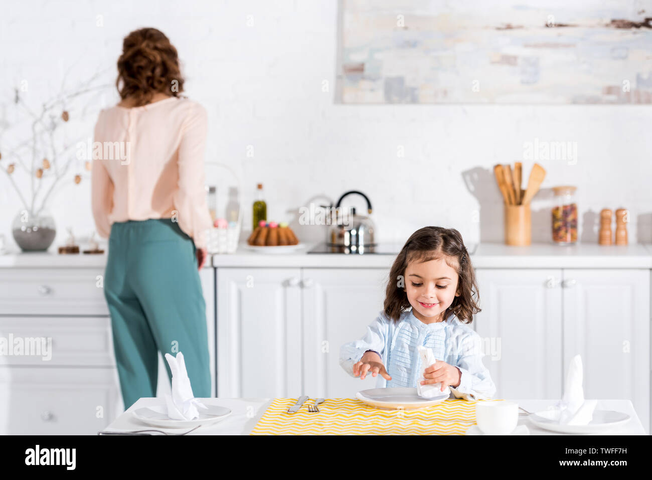 Lächelnd Vorschüler kid Falten Serviette am Tisch in der Küche Stockfoto