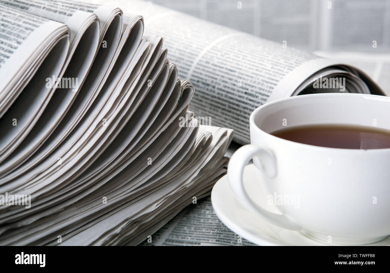 Zeitungen und eine Tasse Kaffee auf dem Tisch closeup Stockfoto