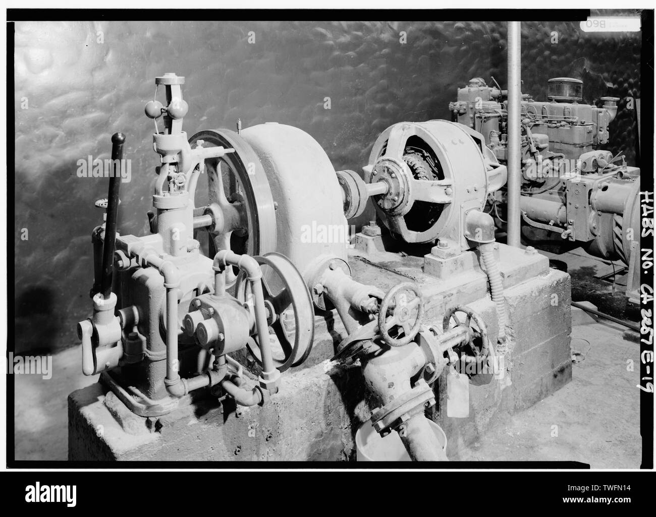 Die Inneneinrichtung, PELTON WASSERTURBINE und FLYBALL GOUVERNEUR DIREKT VERBUNDEN MIT 7 KW AC Generator (RECHTS), 125 Volt, 56 Ampere. Im Jahr 1926, NOCH IMMER FÜR AUSSENBELEUCHTUNG INSTALLIERT. - Death Valley Ranch, Power House, Death Valley Junction, Inyo County, CA Stockfoto