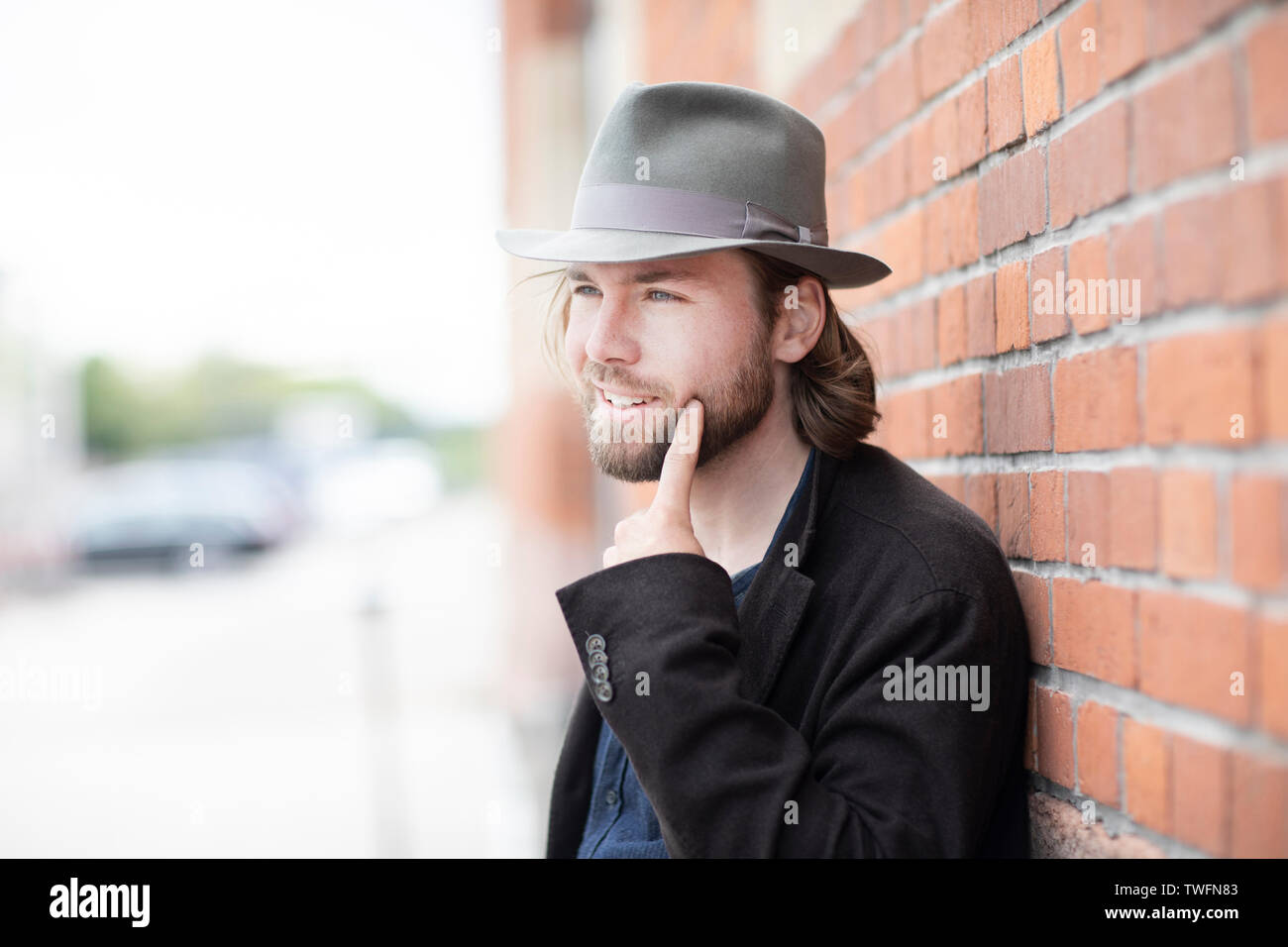 Porträt eines Mannes gegen eine Wand an seinem Gesicht zeigen Schiefe Stockfoto
