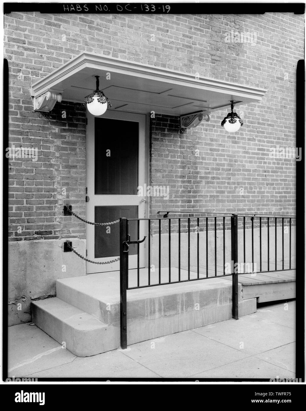 PRIVATE SEITE EINGANG HINZUGEFÜGT 1921 BARRIEREFREI VON DER AUFFAHRT ZUM AUFZUG ZU GEBEN. (Schmiedeeiserne Geländer, erweiterte oberen Schritt der Stoop (durch die dunkleren Beton zwischen den beiden vertikalen Beiträge angezeigt), und Holz- Rampe von der National Trust hinzugefügt modernen barrierefreien Zugang codes, circa 1980.) - Woodrow Wilson House, 2340 South Street, Northwest, Washington, District of Columbia, DC Stockfoto