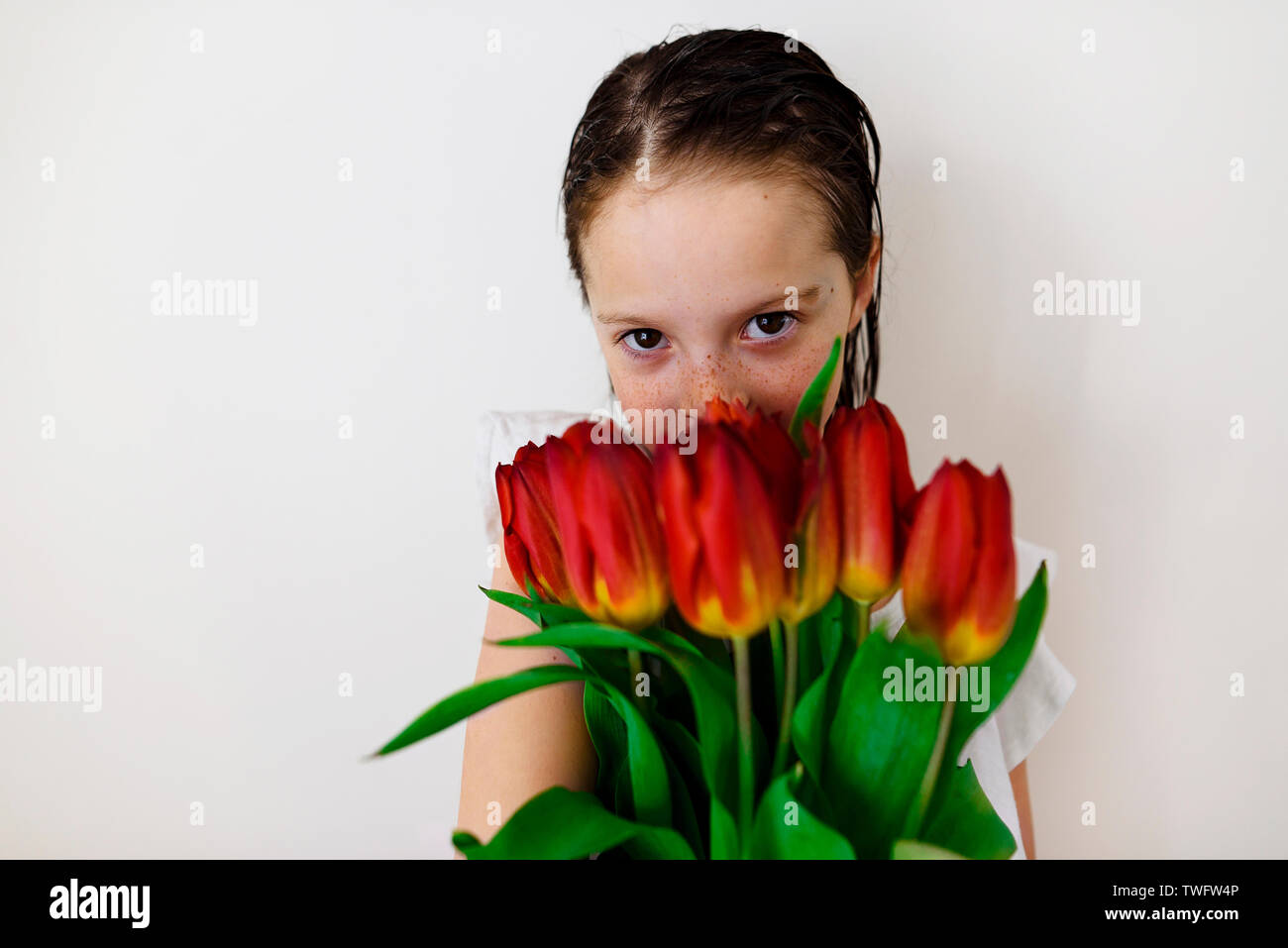 Portrait eines Mädchens mit nassem Haar mit einem Blumenstrauß aus Tulpen Stockfoto