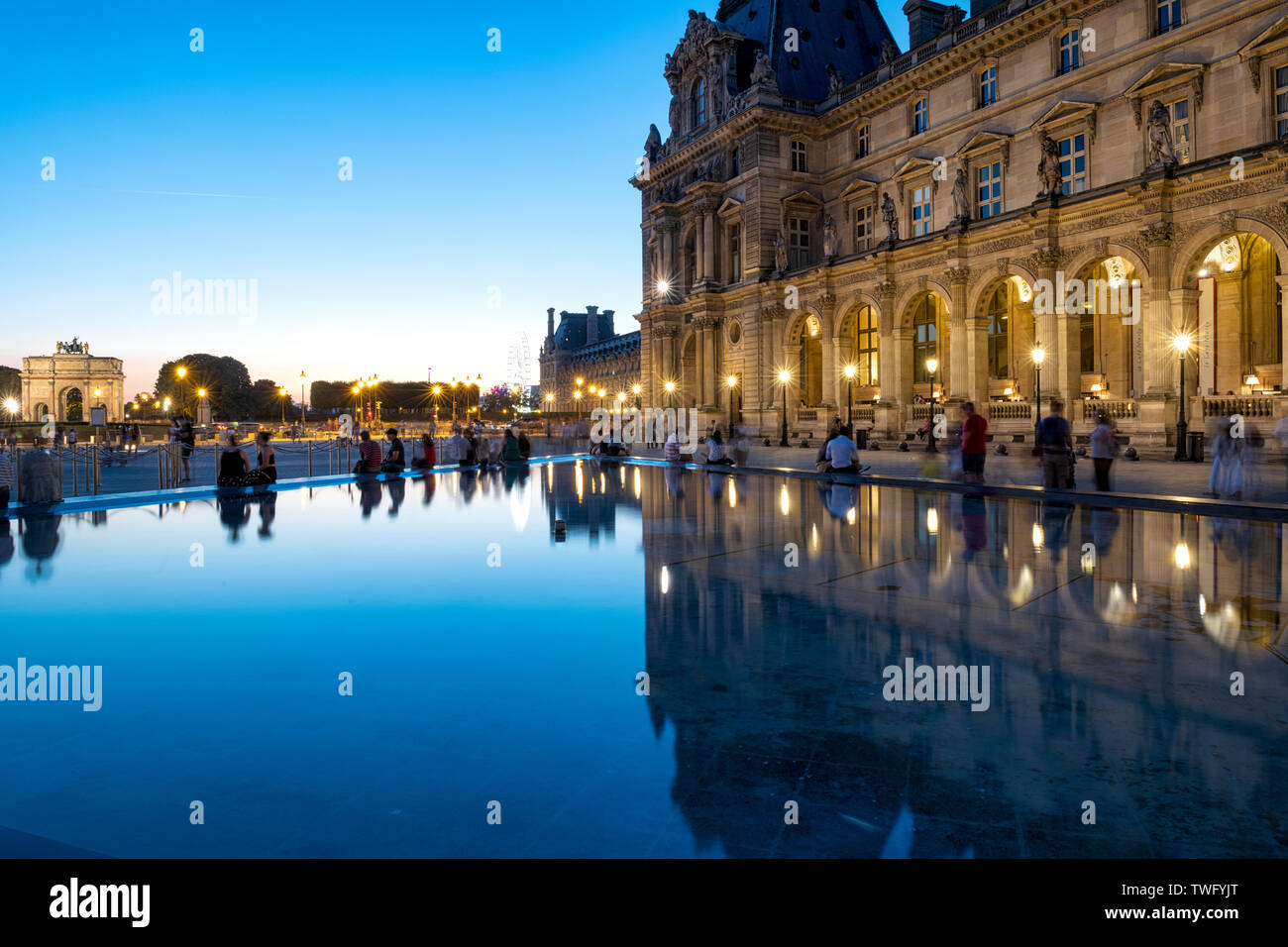 Menschen rund um den Springbrunnen um den Louvre Pyramiden sitzen Stockfoto