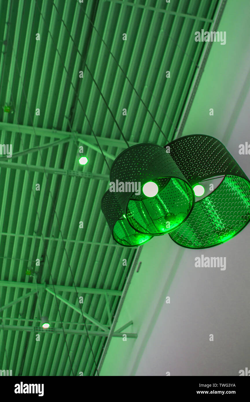 Ultra-modernen Stil in grün getönten Farben dekorative Lampen und Lampenschirme hängen an langen Seil, industriellen Decken, Innenausbau vertikale erschossen. Stockfoto